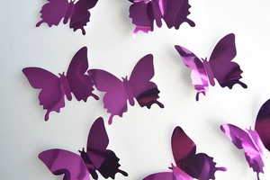 Detailed view of 3D purple mirror-effect butterfly wall stickers on a clean white surface