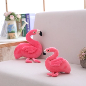 Plush flamingo toy in bright pink with soft texture displayed on a cozy sofa