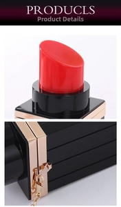 Detail of creative lipstick-shaped acrylic evening bag with gold metal trim and chain