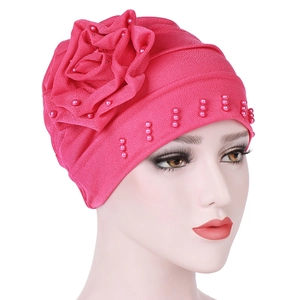 Close-up of rose red turban hat featuring side handmade flower and pink pearl beads