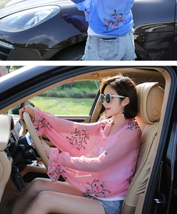 Close-up of floral embroidery on lightweight chiffon beach cover-up with bell sleeves