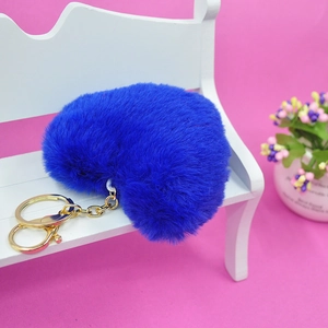 Detalle de llavero de corazón de felpa azul con anilla de metal dorado y gancho