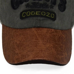 Gros plan sur casquette baseball vintage avec couronne verte et visière en similicuir marron