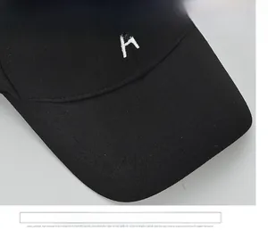 Gros plan sur le bord large et la broderie lettre A blanche sur casquette noire