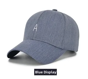 Détail d'une casquette de baseball en jean bleu avec lettre A brodée et visière courbée