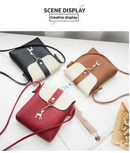 Three mini crossbody bags in black, brown, and red with gold deer charm detail