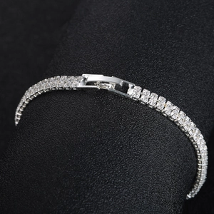 Detailed macro view of silver tennis bracelet with double row rhinestones and fold-over clasp