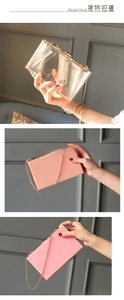 Detail of elegant acrylic dinner clutch with gold chain strap and metal lock closure