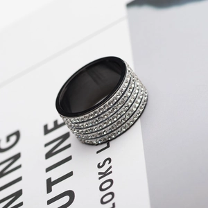 Minimalist black stainless steel wide band ring with 5 rows of crystals on modern background