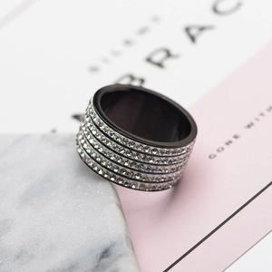 Macro shot of wide black titanium ring with five rows of sparkling silver crystals