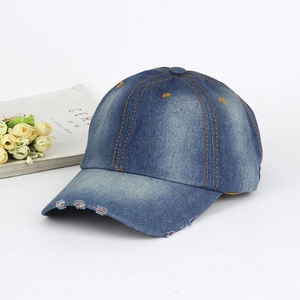 Close-up of washed blue denim baseball cap featuring stylish distressed frayed brim detail