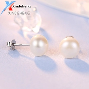 Detailed macro view of S925 silver hallmark on white pearl stud earring stems