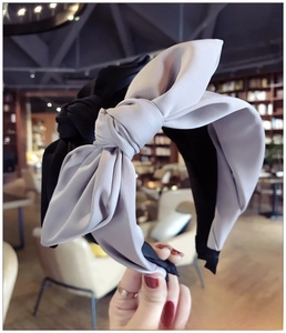 Detail of oversized fabric bow headbands in black and lilac with soft pleated texture