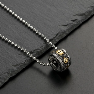 Macro shot of titanium steel lotus pendant with vintage cloud motifs and gold accents