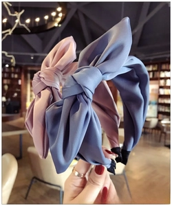 Detailed close-up of blue and purple fabric bow headbands with premium matte texture