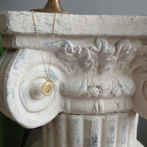 Close-up of gold 925 sterling silver coin necklace featuring Elizabeth II relief on a column