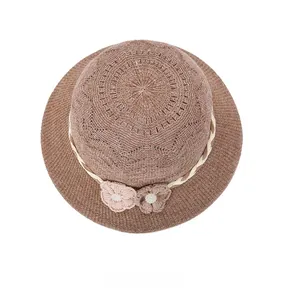 Vue de dessus d'un chapeau de paille marron avec fleurs au crochet et perles nacrées