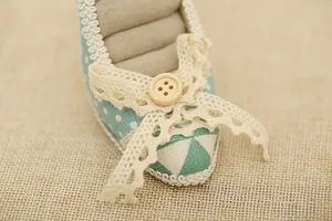 Detail of high heel ring display stand with mint green polka dots and lace bow