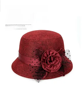 Detailed view of dark red linen sun hat with large satin flower and polka dot mesh veil
