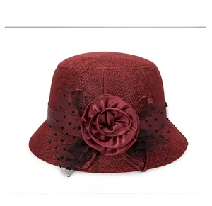 Detail of burgundy linen sun hat featuring a large satin rose and black polka dot mesh veil