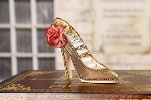 Elegant champagne high heel jewelry stand with red flower and rings in velvet slots
