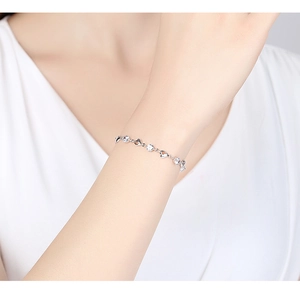 Close-up of 925 sterling silver heart bracelet with sparkling zircon stones on a model