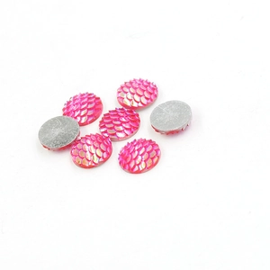 Macro detail of 7 pink round resin fish scale cabochons with iridescent AB glitter finish