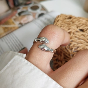 Unique 925 sterling silver hugging hands open ring shown in a close-up lifestyle shot