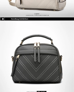 Front view of a dark grey crossbody bag featuring V-quilted faux leather and top handle