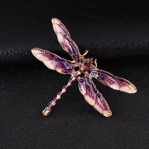 Detail of dragonfly brooch with purple gradient enamel and red rhinestone on black leather