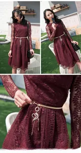 Close-up of golden leaf metal belt with heart pendant on red lace dress detail