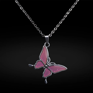 Makro-Detail des silbernen Edelstahl-Schmetterlingsanhängers mit rosa Glitzerflügeln auf Schwarz