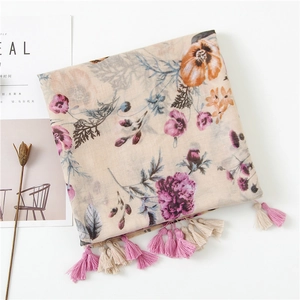 Detailed view of floral cotton scarf with pink and beige tassels on a white background