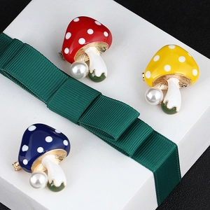 Cute mushroom pins with enamel spots and pearls set on a gift box for sweater decor