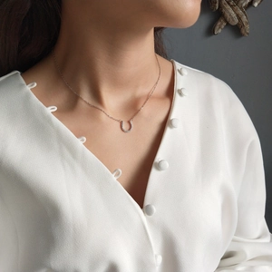 Detailed view of a 925 sterling silver horseshoe necklace with micro-pave cubic zirconia