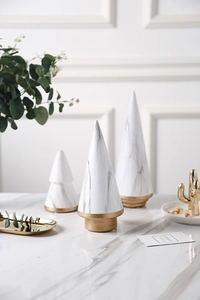Detailed macro view of white marble ceramic Christmas trees with elegant gold metal base