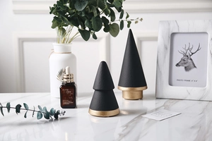 Close-up of matte black ceramic cone ring holders with gold bases on marble surface