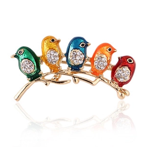 Macro shot of colorful enamel bird brooch with sparkling rhinestones on gold plating