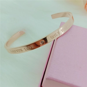 Detailed shot of rose gold open cuff bracelet with Forever Love engraving and small diamond
