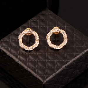 Golden twisted round stud earrings with AAA cubic zirconia micro-pave on a black jewelry box