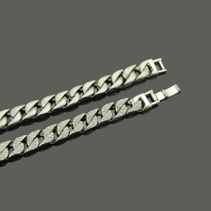 Detail of silver Cuban chain with rhinestones and polished link with buckle closure