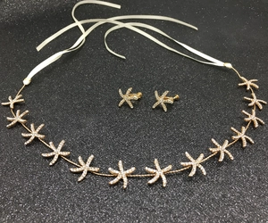 Detail of gold starfish bridal headband with rhinestones and matching clip earrings
