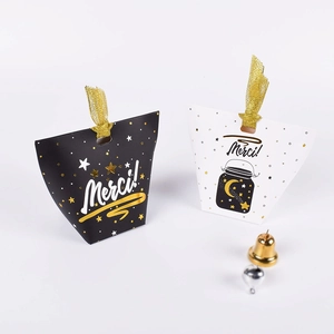 Detail of folding paper gift boxes with gold Merci print and ribbon ties