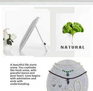 Foldable oval jewelry organizer with grey velvet surface and white pearl trim detail