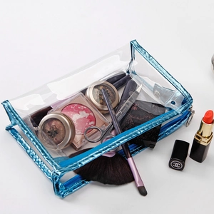 Detailed macro view of a large clear PVC cosmetic bag with metallic blue edge trimming