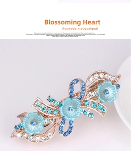 Macro shot of rose gold spring hair clip featuring blue flowers and gradient rhinestones