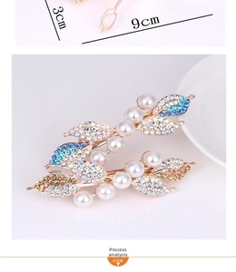 Detailed view of leaf hair clips with pearls and colorful rhinestones measuring 9cm by 3cm