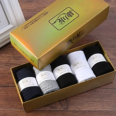 Close-up of five pairs of cotton crew socks in a premium gift box on wooden background