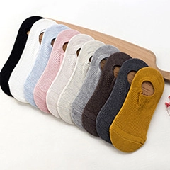 Collection of low cut cotton socks in ten colors on a wooden board display