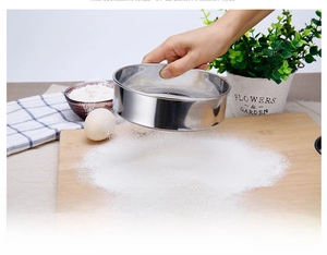 Action shot of 304 stainless steel 60-mesh flour sifter used in a rustic baking scene